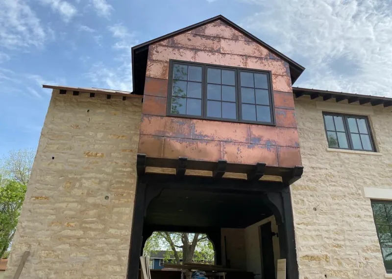 Copper metal panel facade on a stone building for Skylight Installation in Hermantown